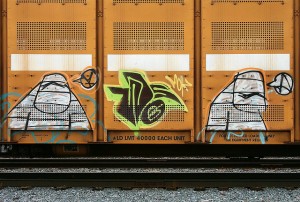 Photo of three graffiti-style creatures on the side of a train